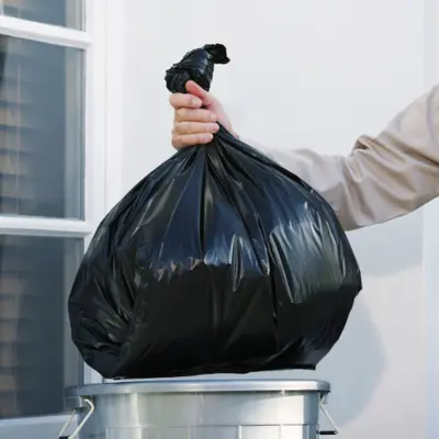 Hand holding garbage bag