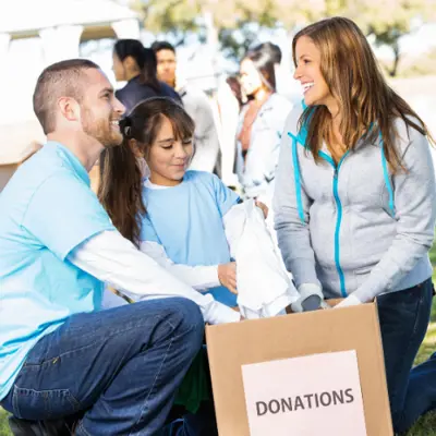 People smiling with donation box